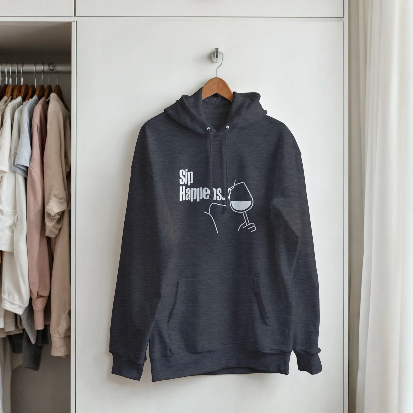 Dark gray hoodie with text and graphic on a hanger against a white wardrobe background
