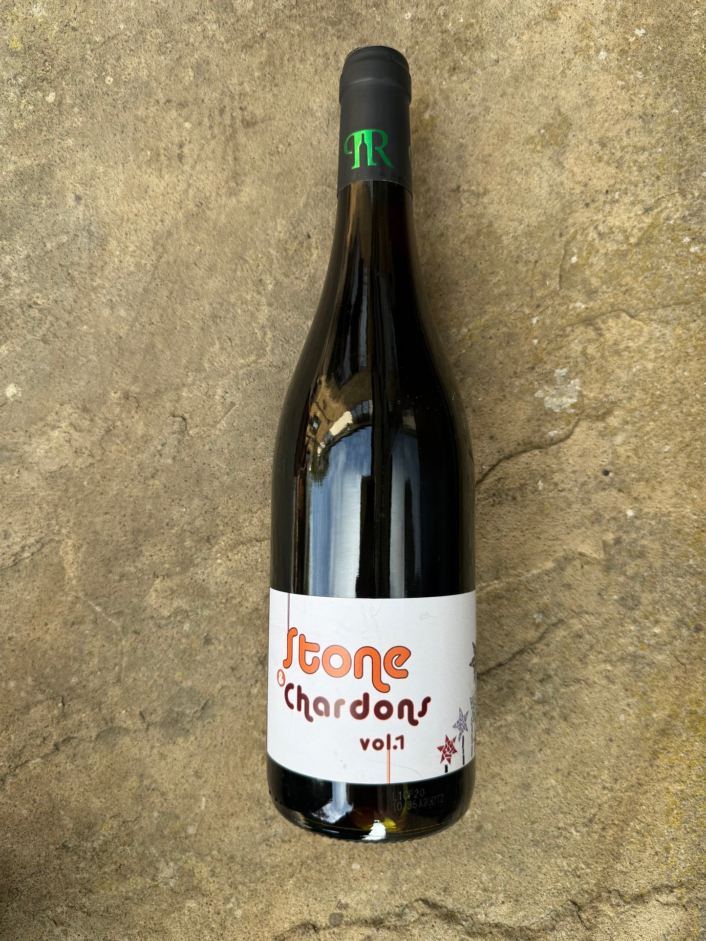 Bottle of Stone & Chardons Vol. 1 by Domaine Pion, a natural red wine with a playful label, photographed on stone—chillable, organic, BBQ-friendly.