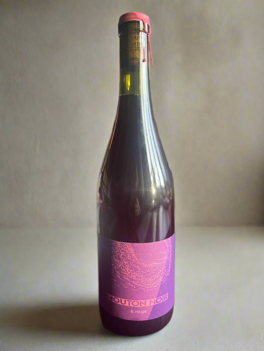 A bottle of Mouton Noir Rouge wine, featuring a striking purple label with elegant text. The wine is showcased on a neutral background, highlighting its premium quality.