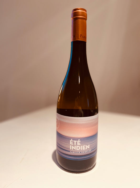 An elegant bottle of Château Paraza orange wine named 'Été Indien', featuring a modern label with soft pastel hues of blue and peach that evoke a serene sunset over the ocean. The label prominently displays the text 'Été Indien Famille Danglas