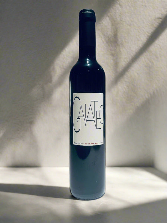 Bottle of Coume del Mas Galateo 2020, an organic old bushvine Grenache wine, standing on a white surface with a minimalist background.