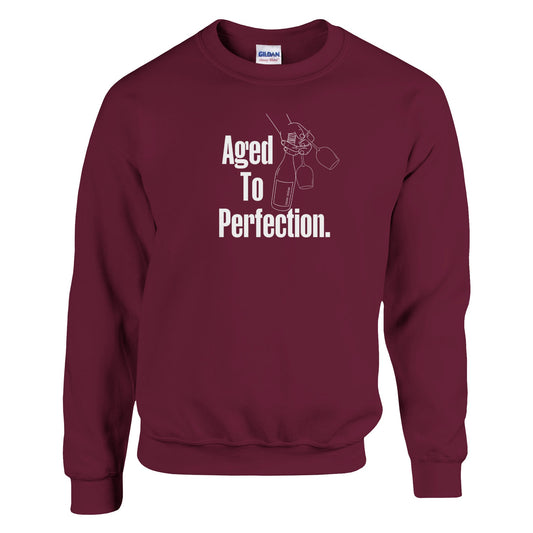 Burgundy oversized sweatshirt with 'Aged to Perfection' white text and champagne bottle design. A stylish and cozy gift for wine and champagne lovers.