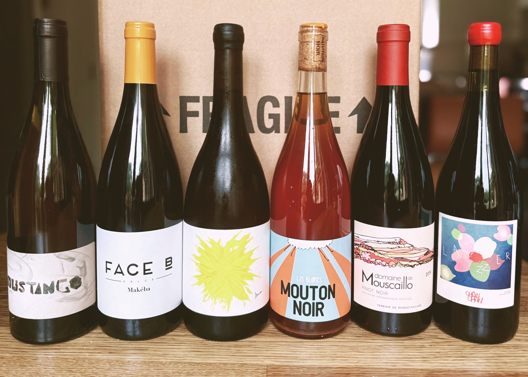 Selection of six natural wines from Taste Union, including Mouton Noir, Jancis Robinson favourite Domaine de Mouscaillo, Chan Chan, Face B, and La Nouvelle Donne, displayed in front of a Taste Union delivery box.