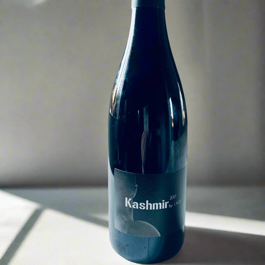 A bottle of La Nouvelle Don(n)e Kashmir 2017 red wine with a minimalist black label. The bottle is set against a clean white background with soft natural lighting.