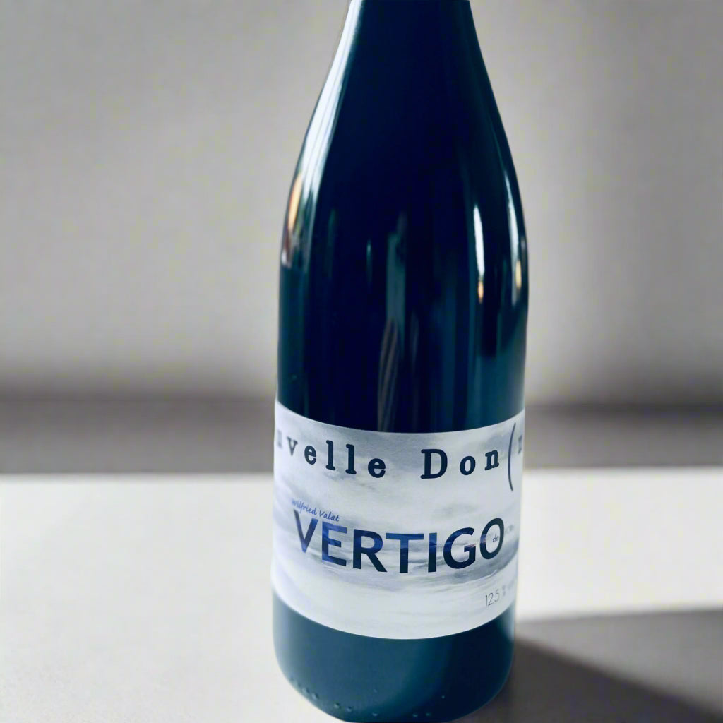 Bottle of La Nouvelle Donne Vertigo 2017 red wine with a minimalist label, showcasing biodynamic craftsmanship, set against a neutral background.